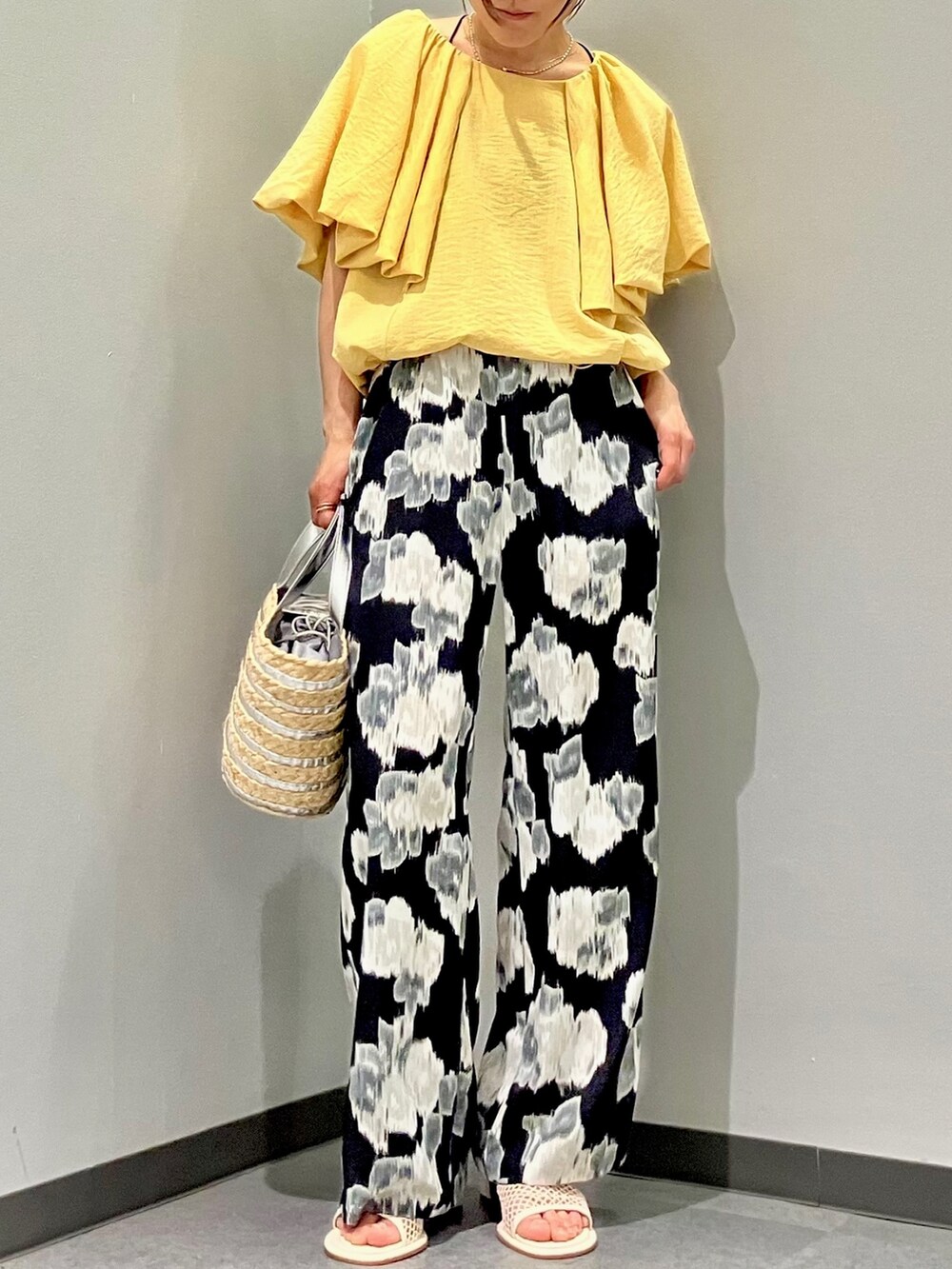 イエロー系のシャツ/ブラウス、シルバー系のかごバッグ、ブラック系のその他パンツを着用したレディースの夏コーディネートの4枚目の写真