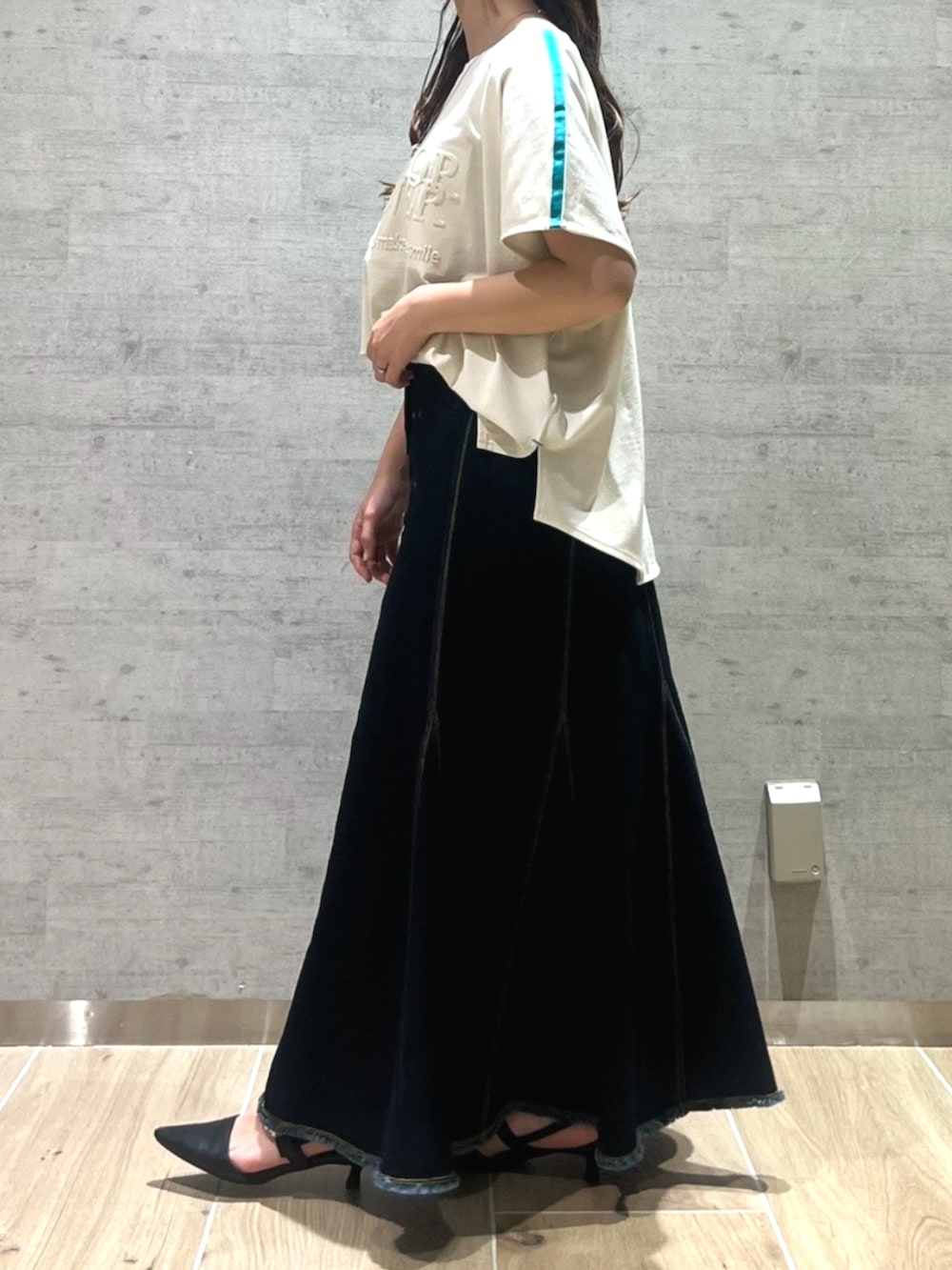 ブルー系のデニムスカート、ホワイト系のTシャツ/カットソーを着用したレディースの夏コーディネートの3枚目の写真