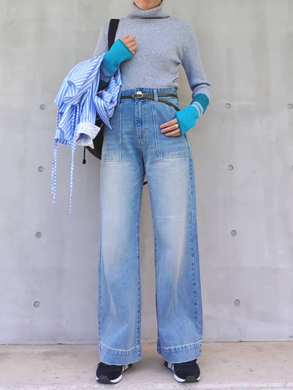 ブルー系のシャツ/ブラウス、グレー系のニット/セーター、ブラック系のバックパック/リュックを着用したレディースの冬コーディネートの3枚目の写真