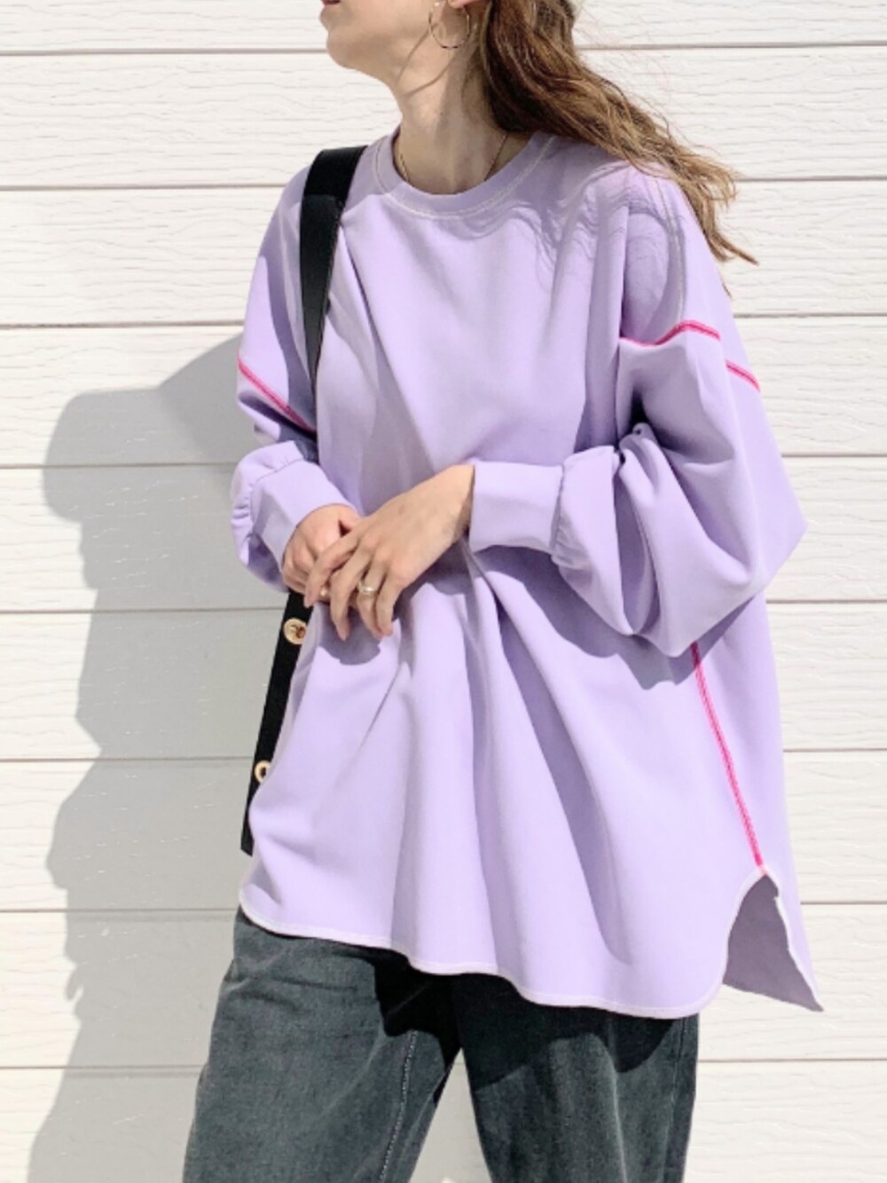 グレー系のデニムパンツ、ブラック系のトートバッグ、パープル系のTシャツ/カットソーを着用したレディースの春コーディネートの3枚目の写真