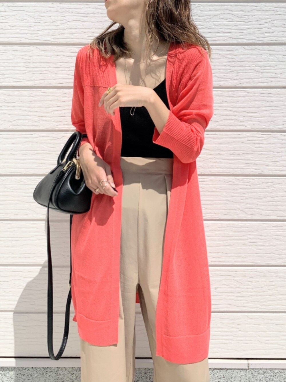 ベージュ系のその他パンツ、ブラック系のショルダーバッグ、オレンジ系のカーディガン/ボレロを着用したレディースの春コーディネートの4枚目の写真