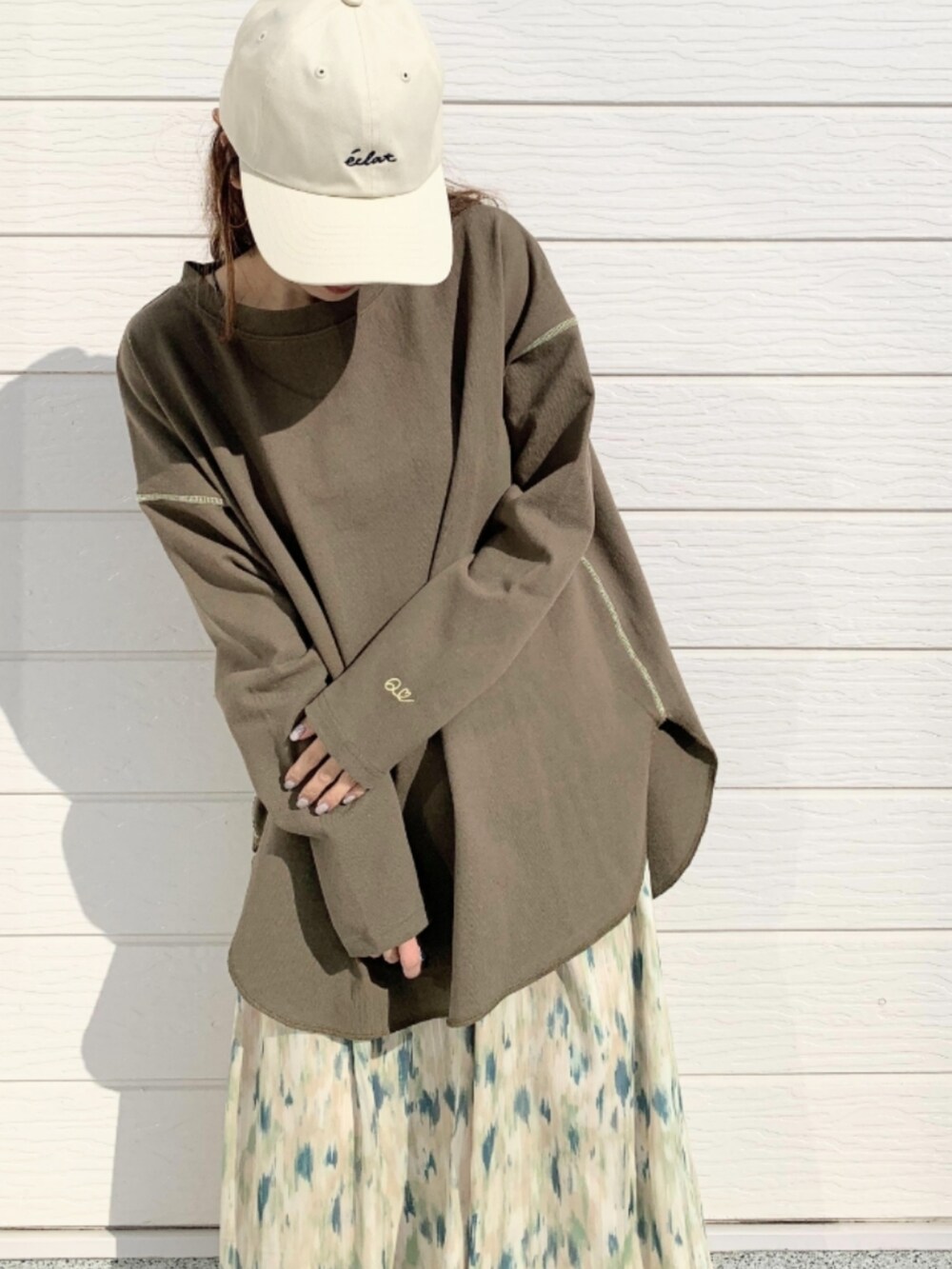 グリーン系のスカート、グリーン系のTシャツ/カットソー、ホワイト系のスニーカーを着用したレディースの冬コーディネートの4枚目の写真