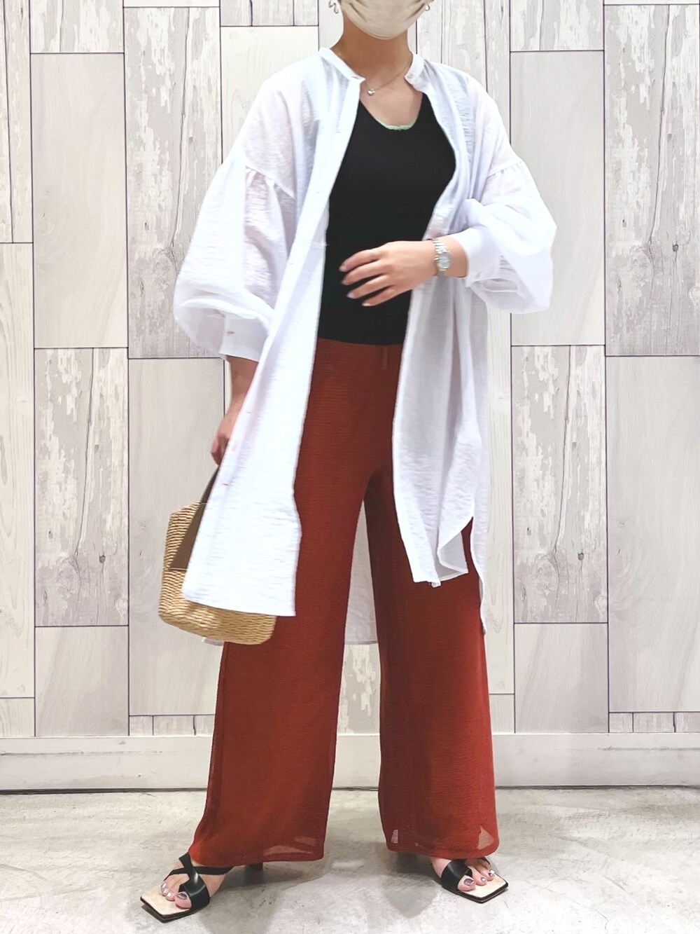 ブラウン系のかごバッグ、ブラウン系のパンツ、ホワイト系のシャツ/ブラウスを着用したレディースの夏コーディネートの2枚目の写真