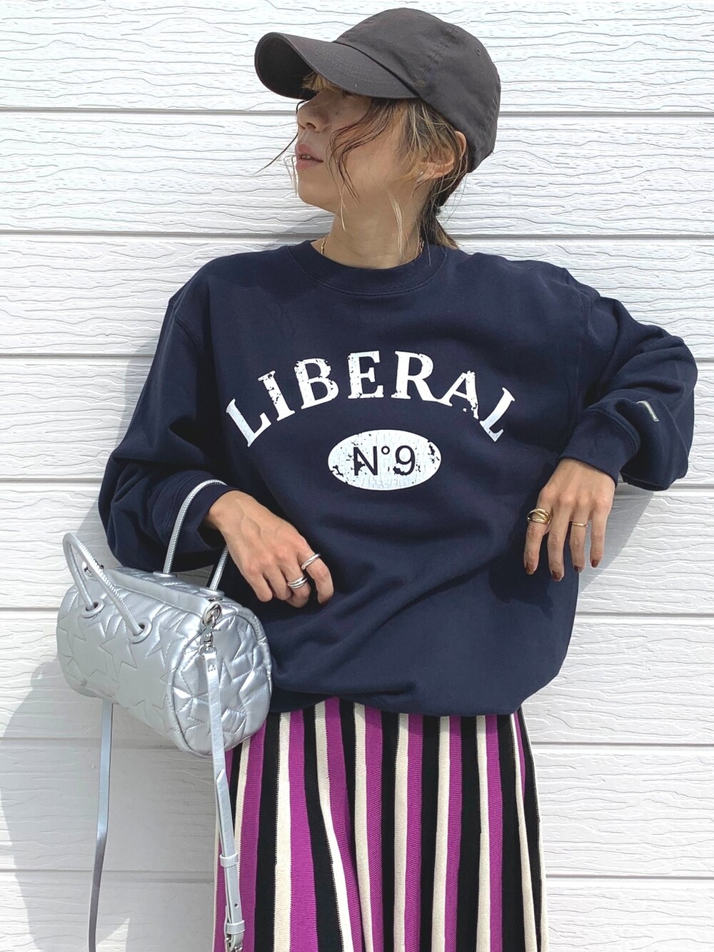 ブルー系のスウェット、ピンク系のスカート、シルバー系のスニーカーを着用したレディースの秋コーディネートの3枚目の写真