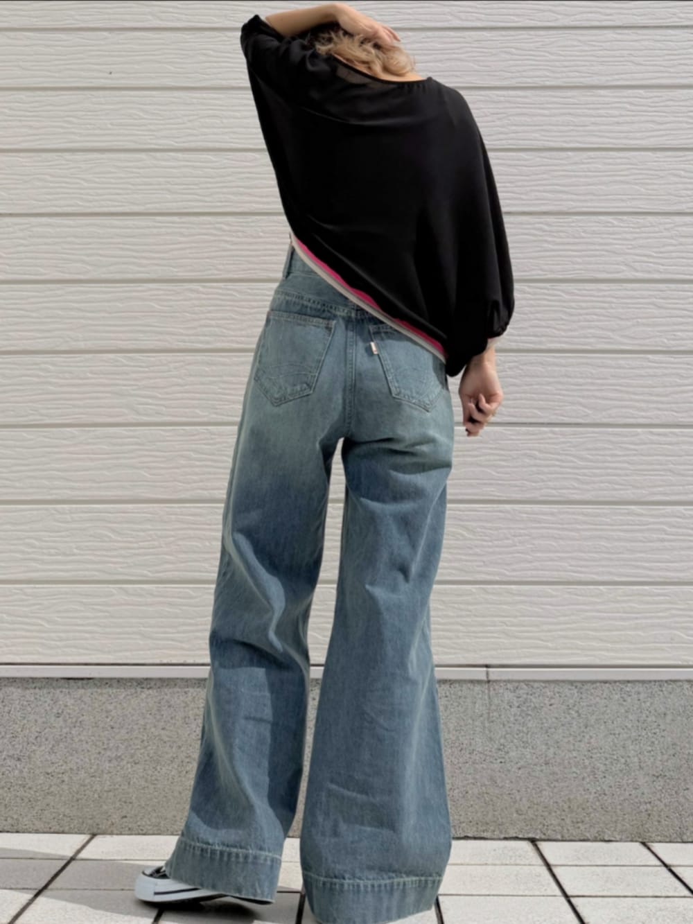 ブルー系のデニムパンツ、ブラック系のスニーカー、ブラック系のシャツ/ブラウスを着用したレディースの春コーディネートの3枚目の写真