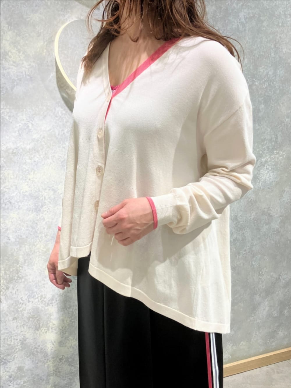 シルバー系のスニーカー、ベージュ系のカーディガン/ボレロ、ブラック系のスカートを着用したレディースの冬コーディネートの3枚目の写真