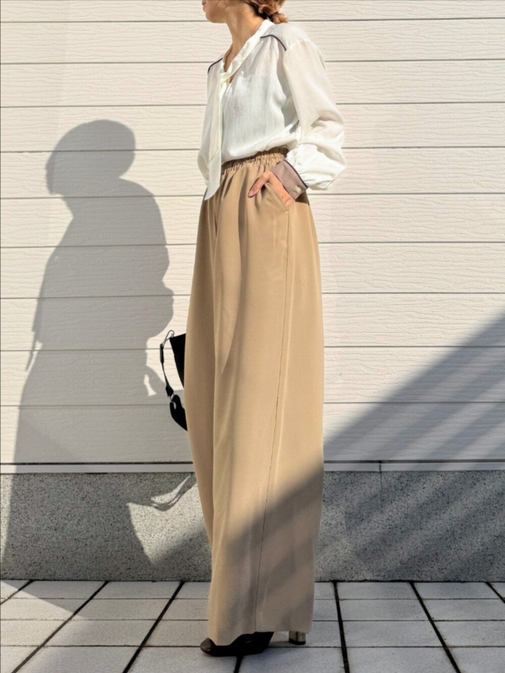 ブラック系のトートバッグ、ベージュ系のその他パンツ、ホワイト系のシャツ/ブラウスを着用したレディースの冬コーディネートの2枚目の写真