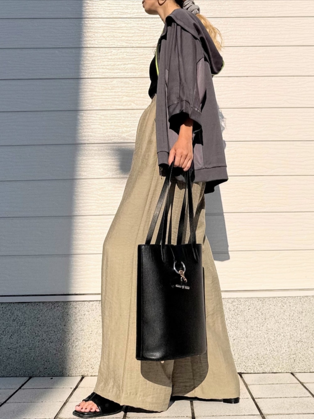 ブラック系のトートバッグ、ブラック系のタンクトップ、グリーン系のその他パンツを着用したレディースの夏コーディネートの2枚目の写真