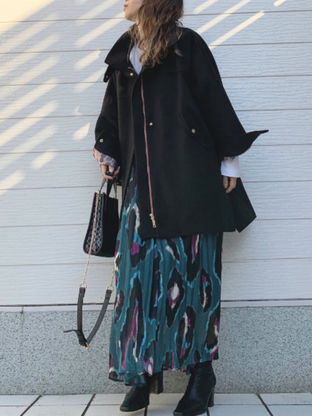 ブラック系のその他アウター、グリーン系のスカート、ブラック系のショルダーバッグを着用したレディースの秋コーディネートの2枚目の写真