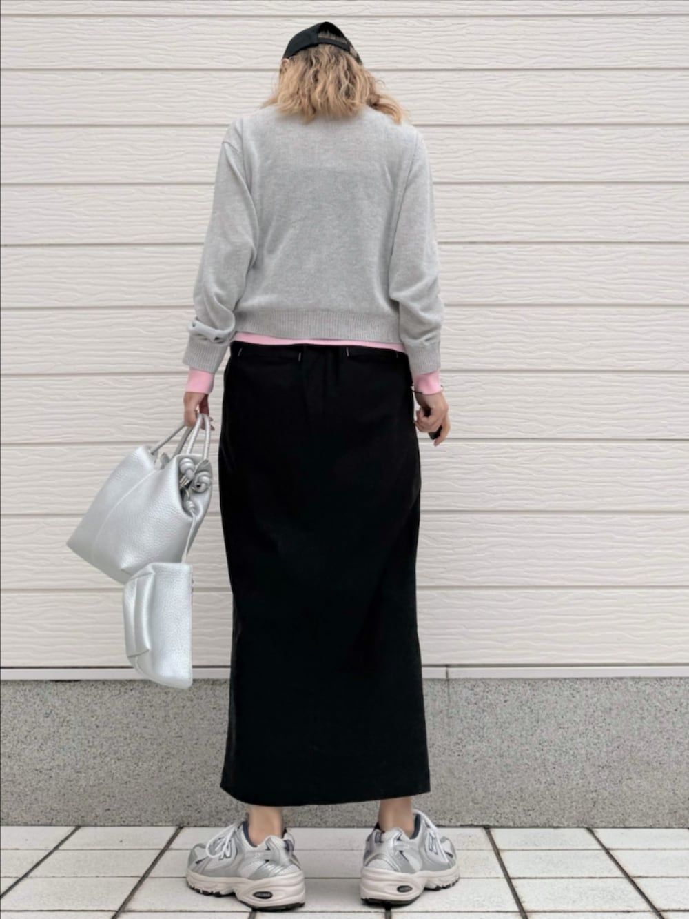 シルバー系のスニーカー、ブラック系のスカート、シルバー系のトートバッグを着用したレディースの春コーディネートの3枚目の写真