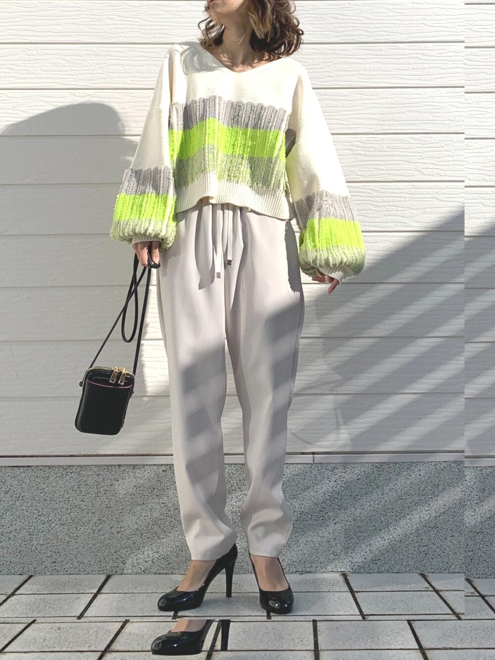 ホワイト系のその他パンツ、ブラック系のショルダーバッグ、ホワイト系のニット/セーターを着用したレディースの冬コーディネートの2枚目の写真