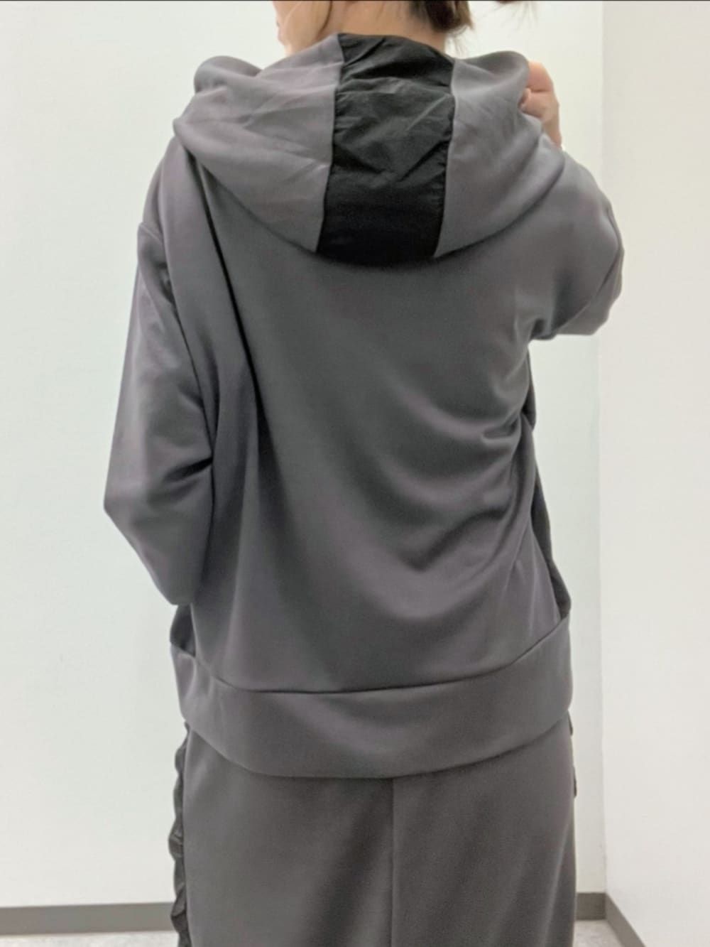 グレー系のスカート、グレー系のパーカー、ホワイト系のブーツを着用したレディースの秋コーディネートの4枚目の写真