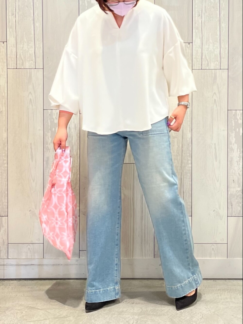 ピンク系のエコバッグ/サブバッグ、ブルー系のデニムパンツ、ホワイト系のシャツ/ブラウスを着用したレディースの春コーディネートの2枚目の写真