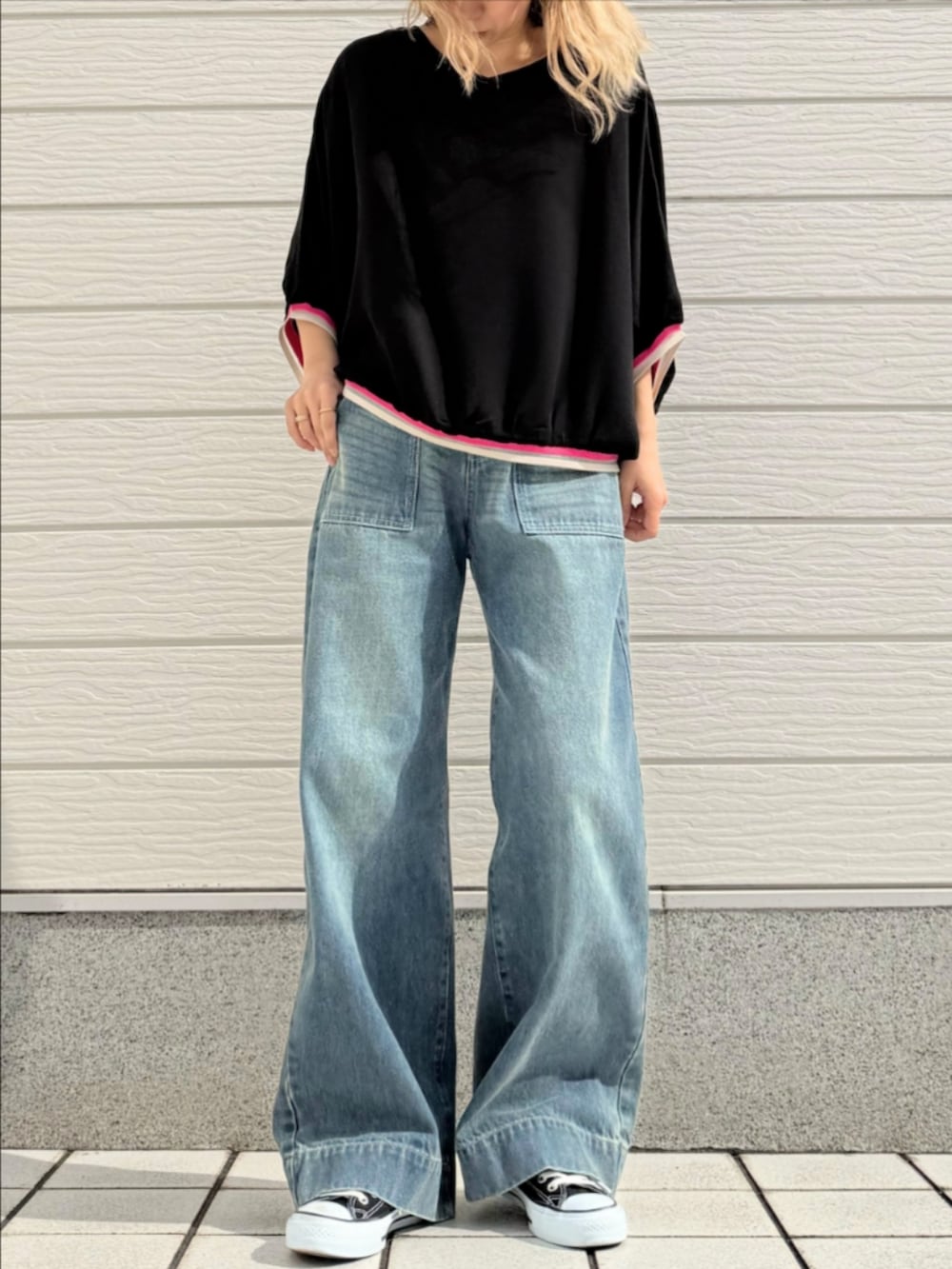 ブルー系のデニムパンツ、ブラック系のスニーカー、ブラック系のシャツ/ブラウスを着用したレディースの春コーディネートの2枚目の写真