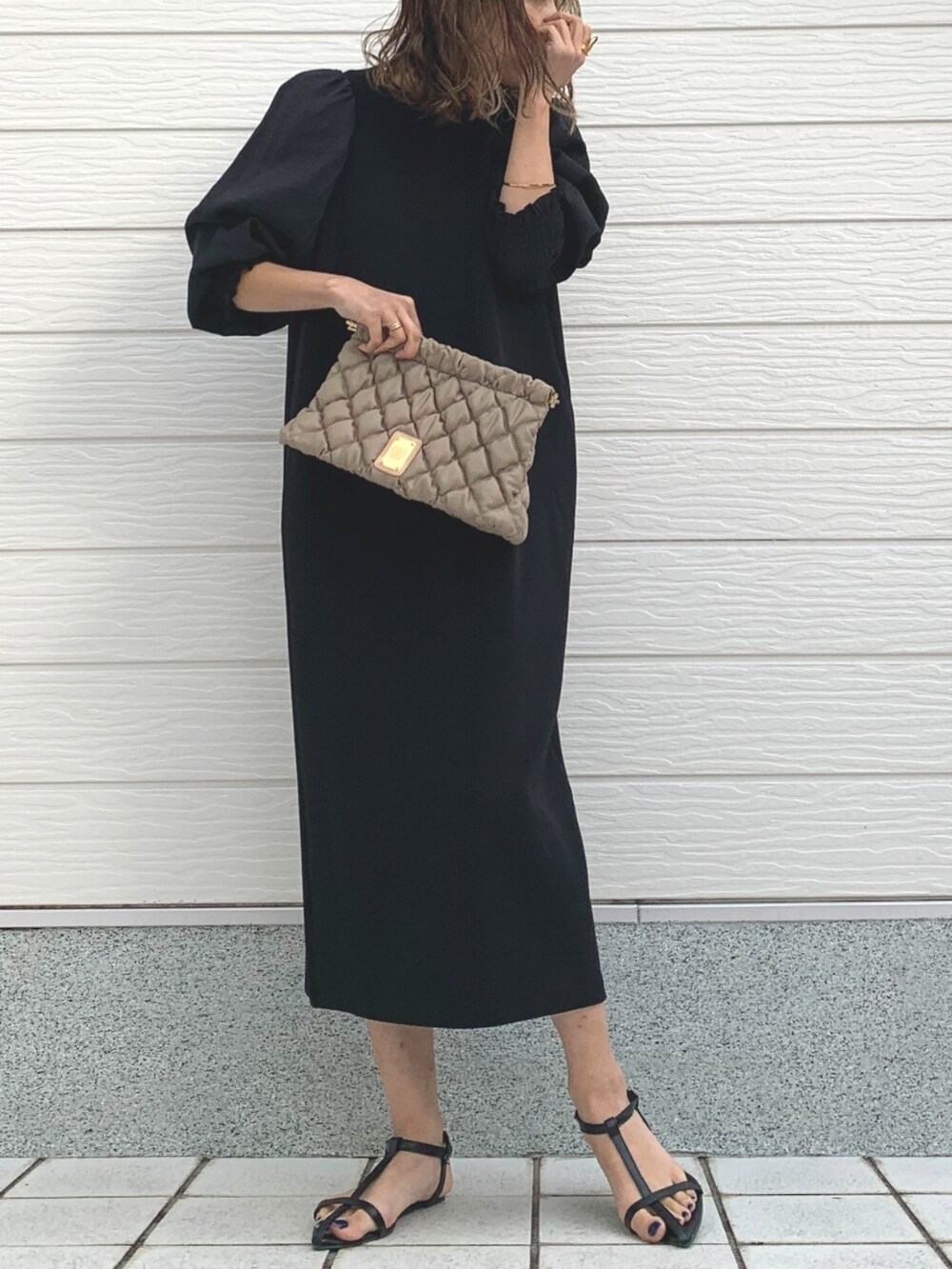 ベージュ系のショルダーバッグ、ブラック系のワンピースを着用したレディースの冬コーディネートの2枚目の写真
