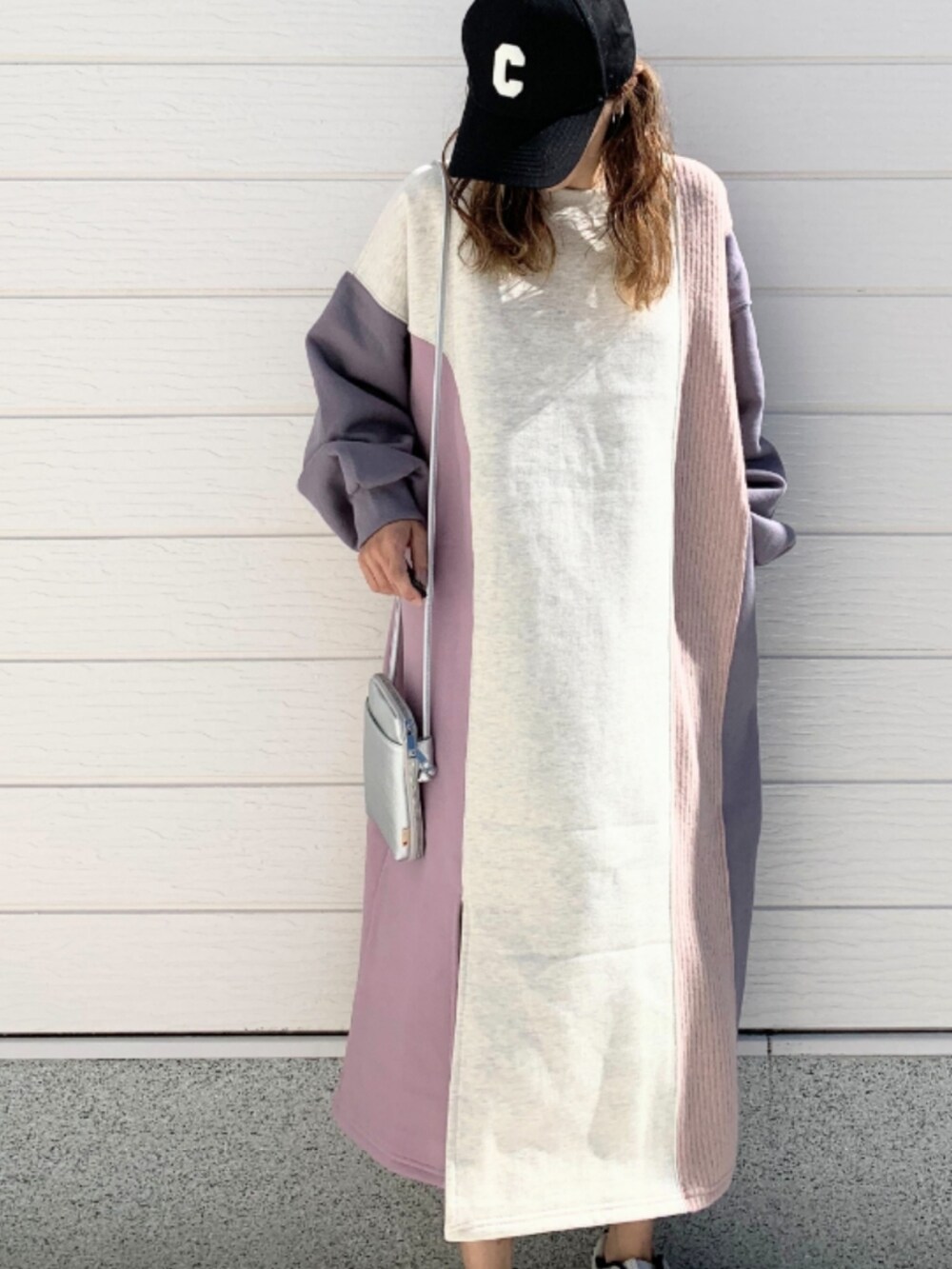 シルバー系のスニーカー、シルバー系のショルダーバッグ、ピンク系のワンピースを着用したレディースの秋コーディネートの4枚目の写真