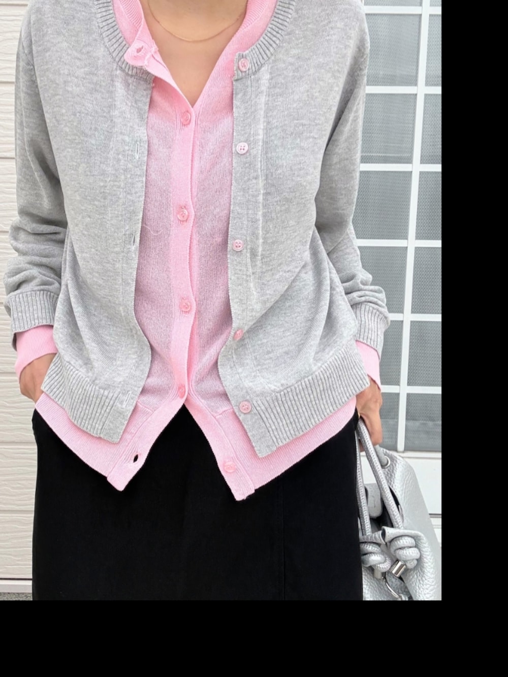 シルバー系のスニーカー、ブラック系のスカート、シルバー系のトートバッグを着用したレディースの春コーディネートの4枚目の写真