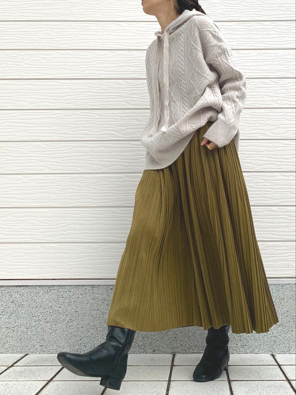 ブラック系のブーツ、ベージュ系のショルダーバッグ、ホワイト系のニット/セーターを着用したレディースの冬コーディネートの3枚目の写真