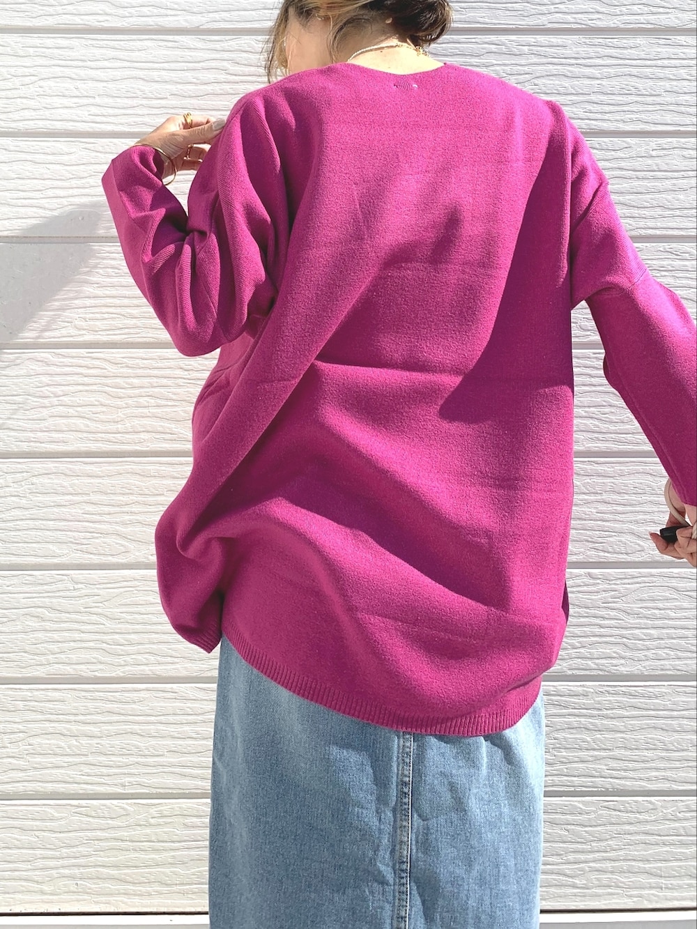ブルー系のデニムスカート、ホワイト系のショルダーバッグ、ピンク系のニット/セーターを着用したレディースの秋コーディネートの4枚目の写真