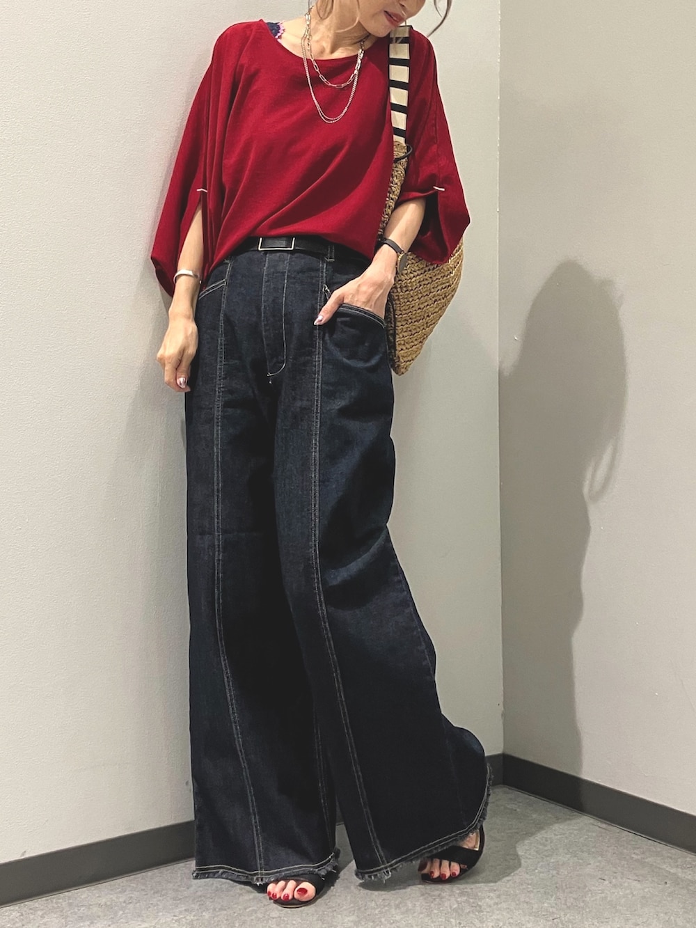 ブルー系のデニムパンツ、レッド系のシャツ/ブラウス、グリーン系のトートバッグを着用したレディースの夏コーディネートの5枚目の写真