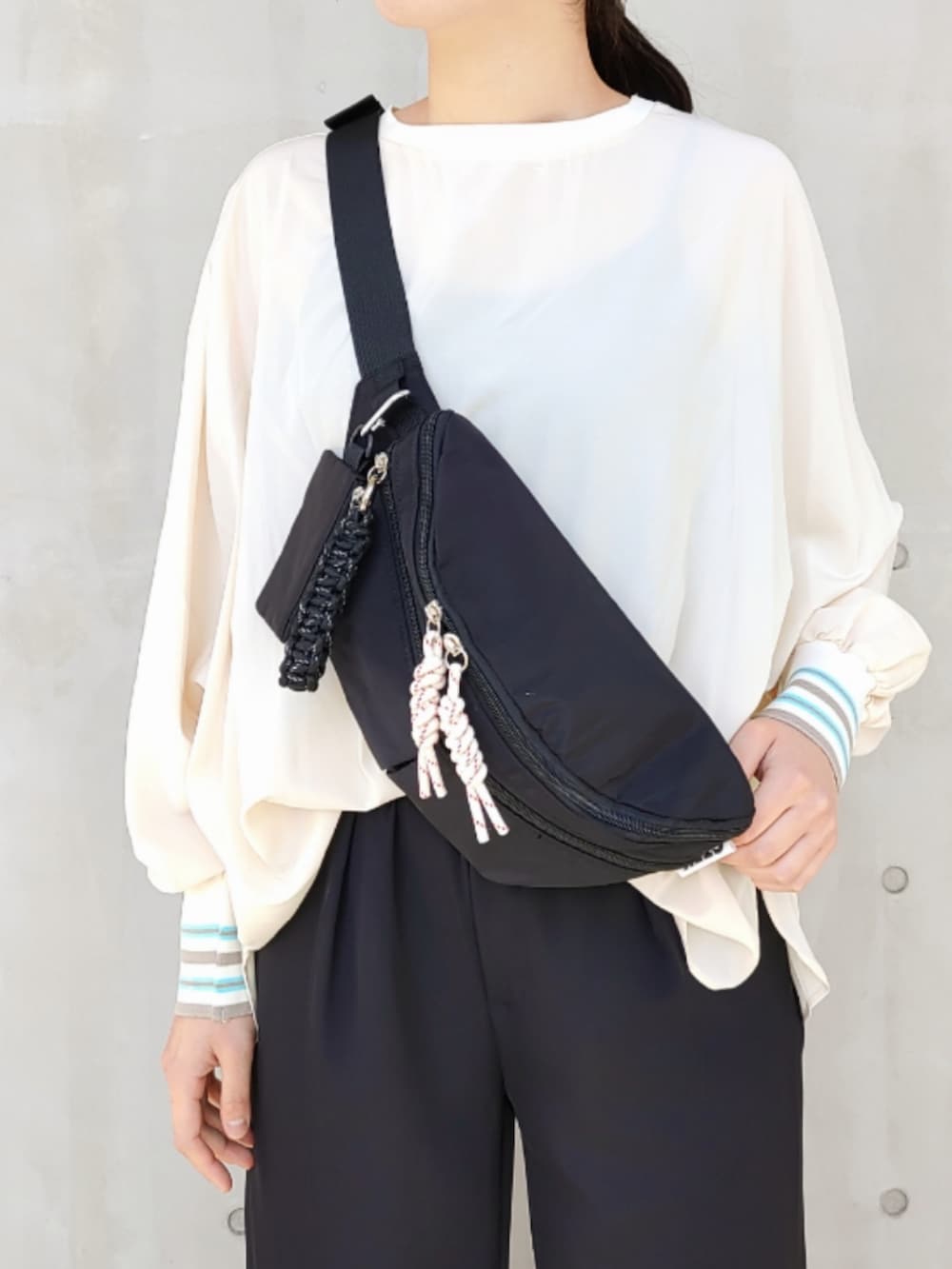 ホワイト系のスニーカー、ブラック系のスラックス、ホワイト系のシャツ/ブラウスを着用したレディースの春コーディネートの4枚目の写真