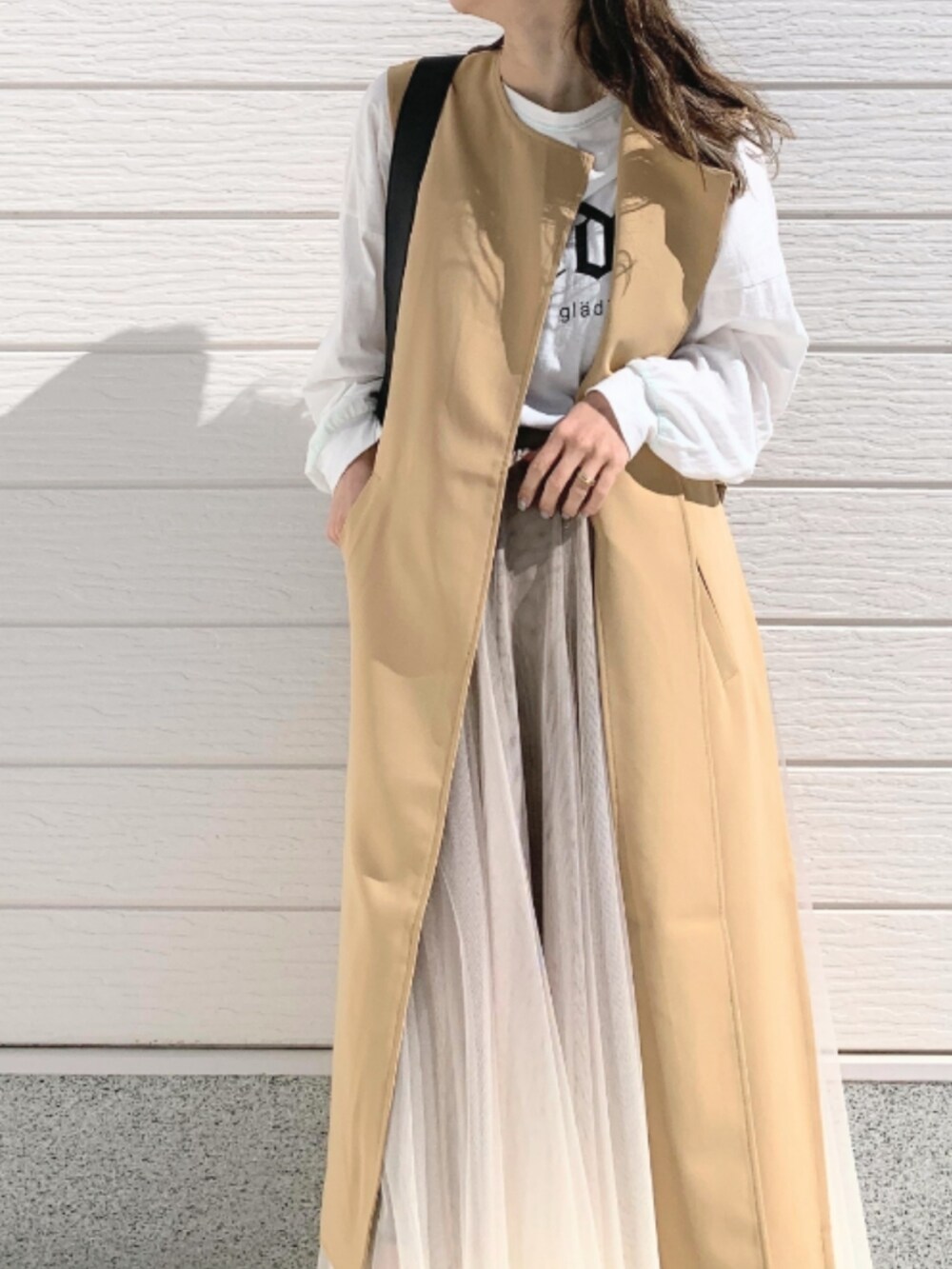 ホワイト系のTシャツ/カットソー、ブラック系のトートバッグ、ゴールド系のスカートを着用したレディースの春コーディネートの4枚目の写真