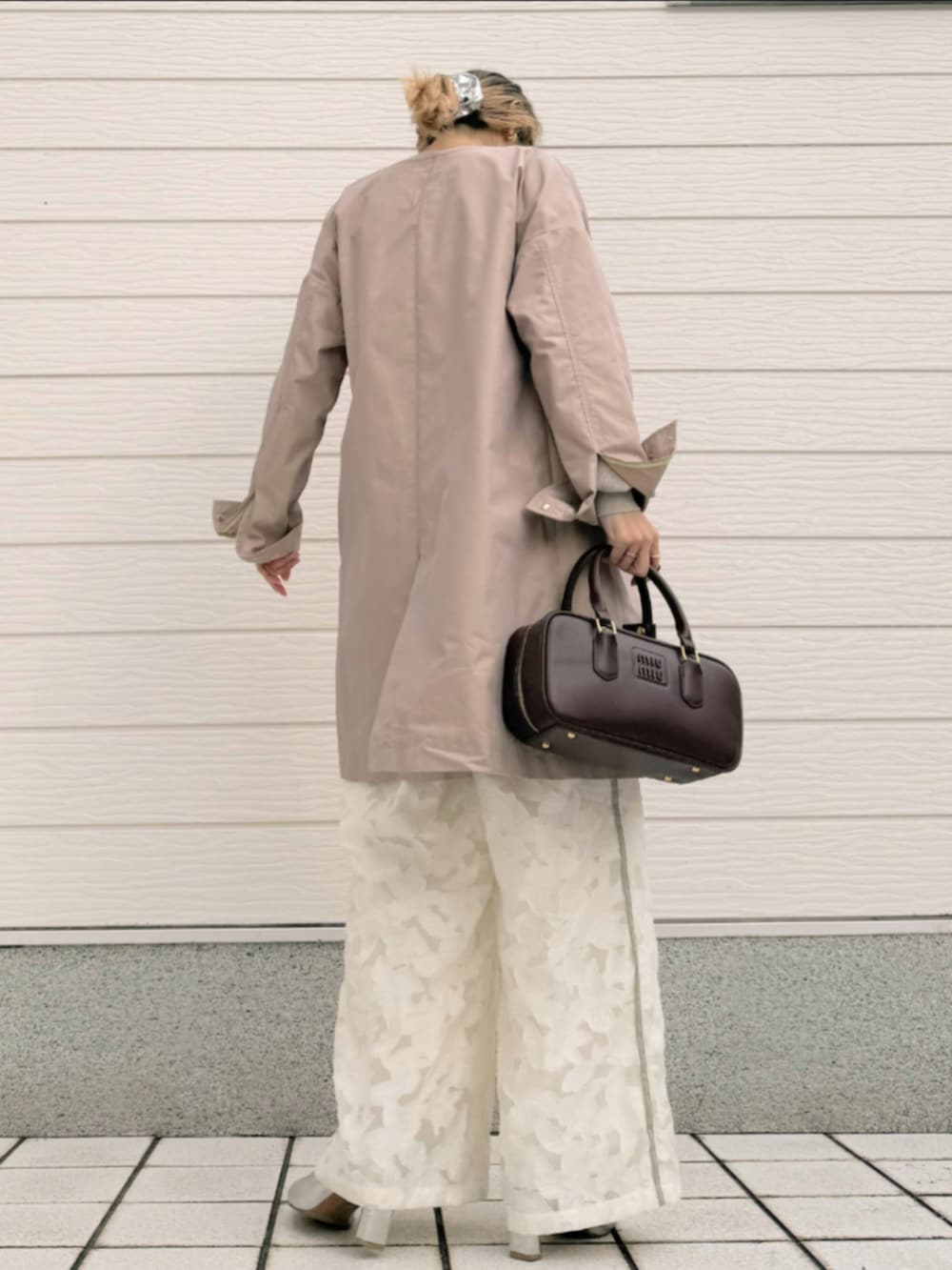 グレー系のニット/セーター、ホワイト系のその他パンツ、ベージュ系のノーカラーコートを着用したレディースの冬コーディネートの3枚目の写真