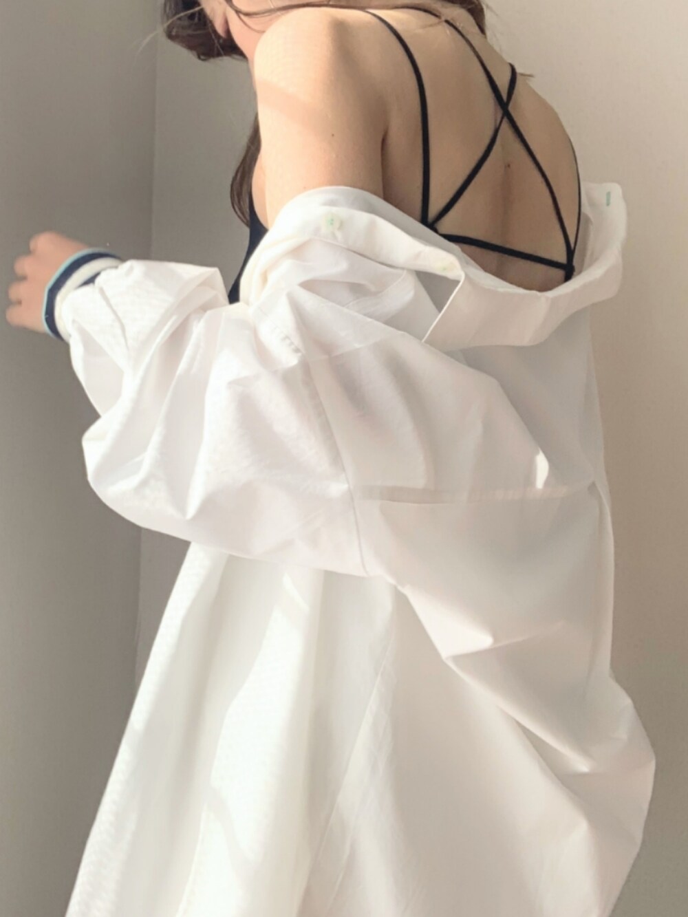 ブルー系のデニムパンツ、ホワイト系のシャツ/ブラウス、ブラック系のキャミソールを着用したレディースの冬コーディネートの5枚目の写真