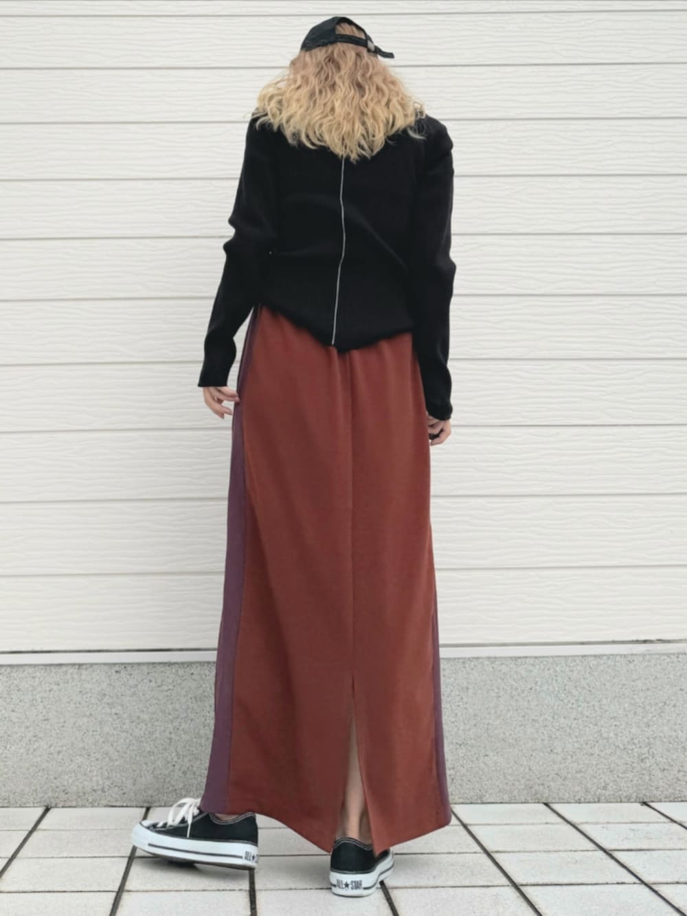 ブラック系のスニーカー、ブラック系のニット/セーター、ブラウン系のスカートを着用したレディースの秋コーディネートの3枚目の写真