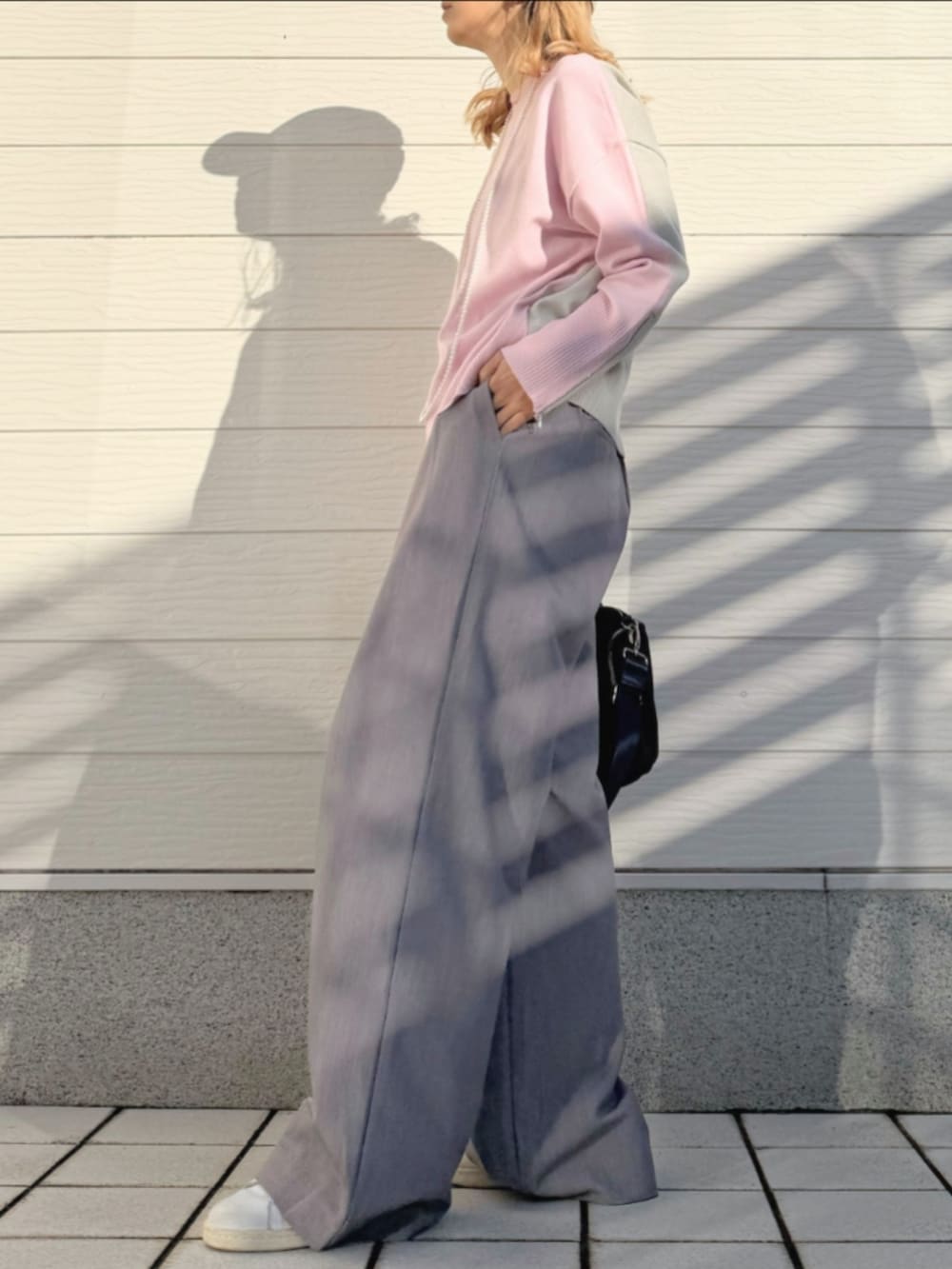 ホワイト系のスニーカー、グレー系のスラックス、ピンク系のニット/セーターを着用したレディースの冬コーディネートの2枚目の写真