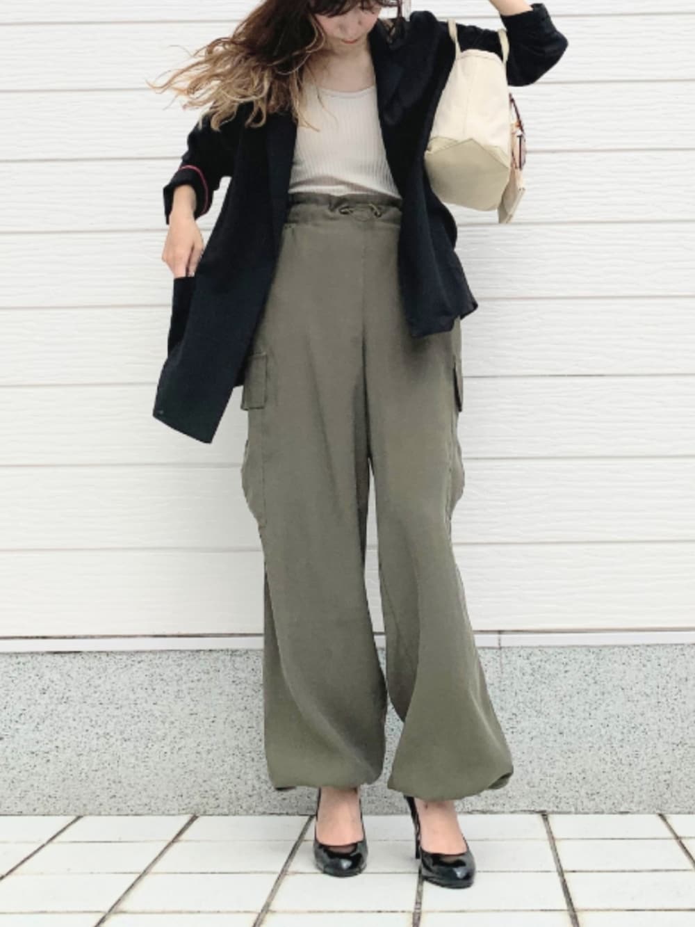 グリーン系のカーゴパンツ、ベージュ系のトートバッグ、ベージュ系のキャミソールを着用したレディースの夏コーディネートの2枚目の写真