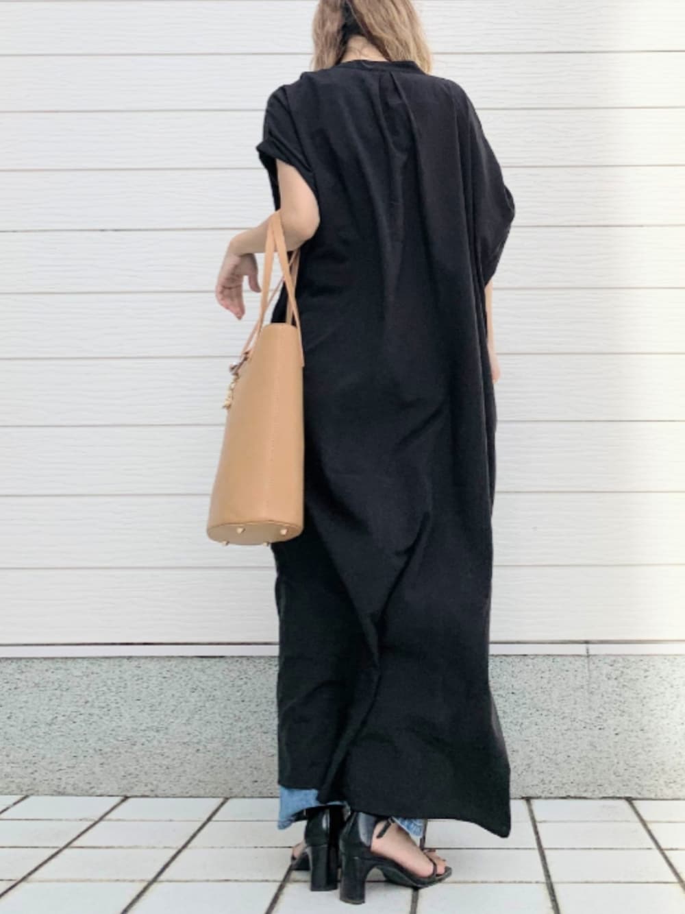 グレー系のトートバッグ、ブルー系のデニムパンツ、ブラック系のシャツワンピースを着用したレディースの夏コーディネートの3枚目の写真