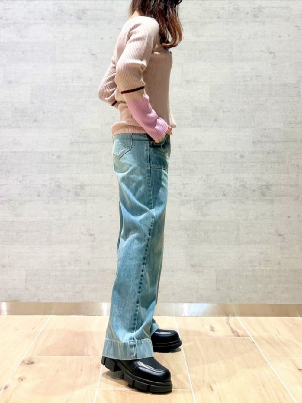 ブルー系のデニムパンツ、ピンク系のニット/セーターを着用したレディースの秋コーディネートの3枚目の写真