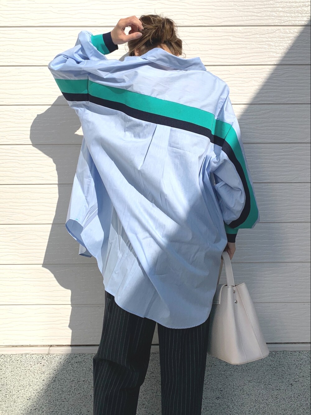 ブルー系のその他パンツ、ホワイト系のハンドバッグ、ブラック系のキャミソールを着用したレディースの春コーディネートの4枚目の写真