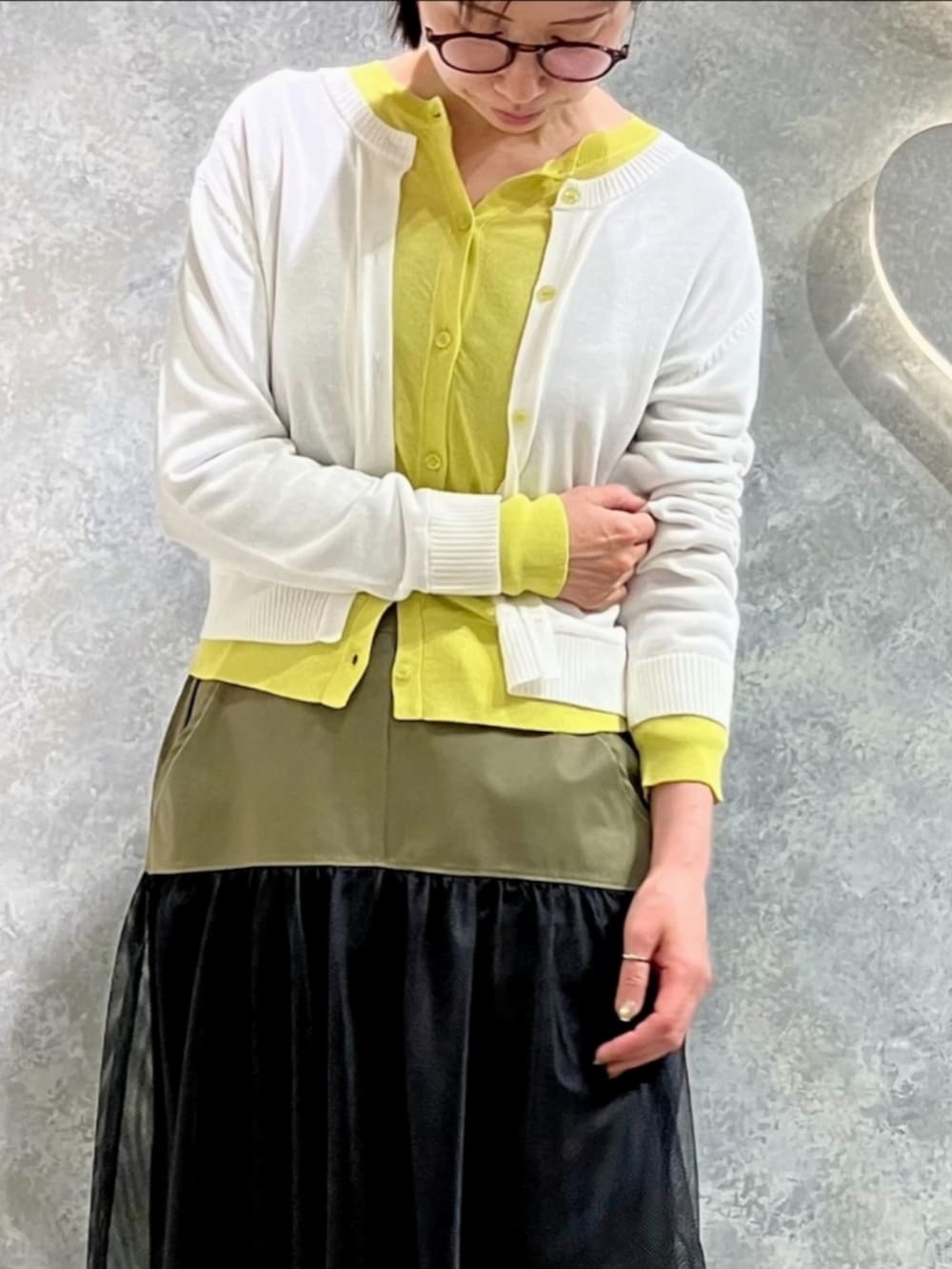 ブラック系のスカート、ホワイト系のカーディガン/ボレロを着用したレディースの春コーディネートの4枚目の写真