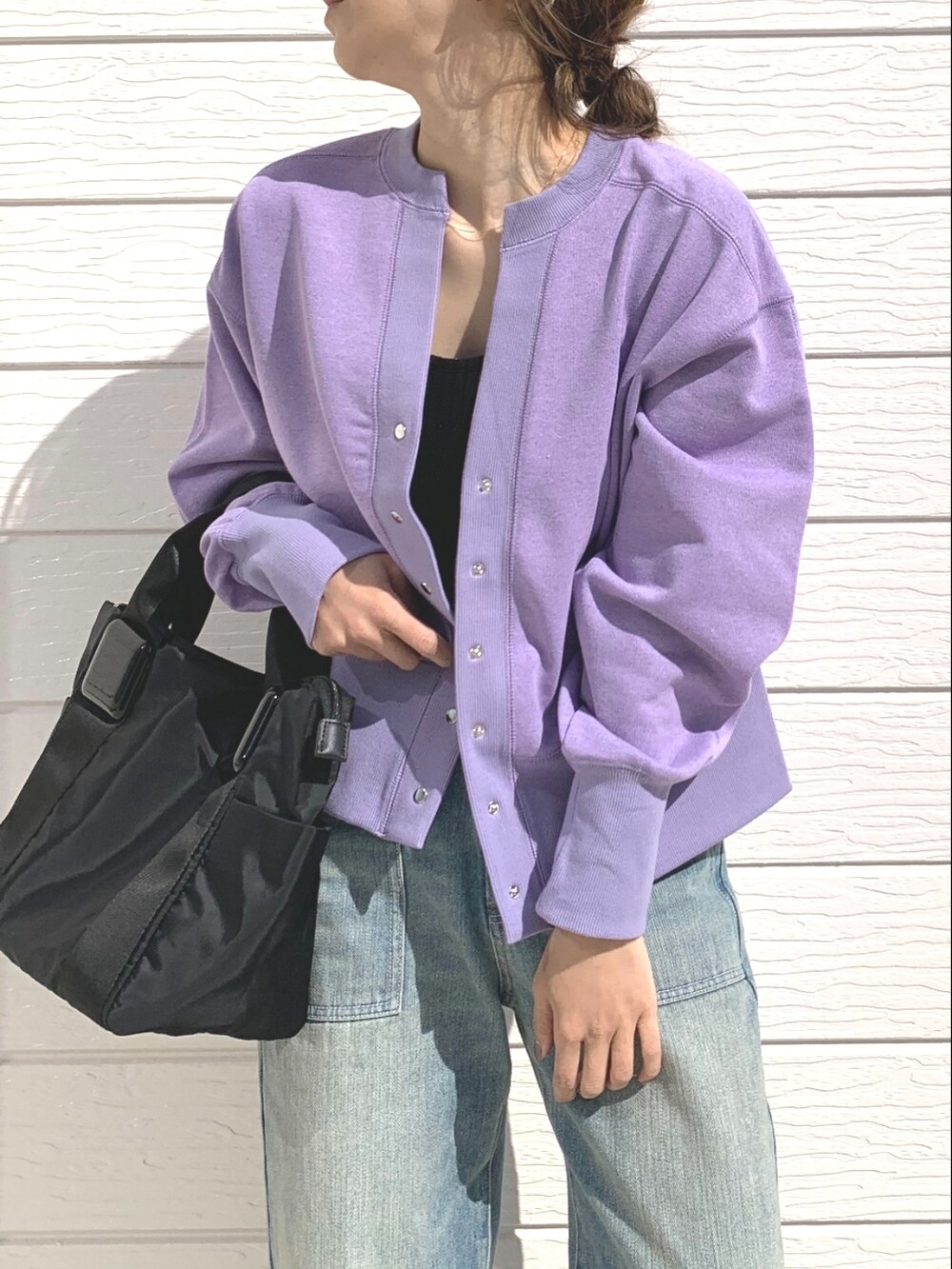 ブラック系のトートバッグ、ブルー系のデニムパンツ、ブラック系のサンダルを着用したレディースの春コーディネートの3枚目の写真