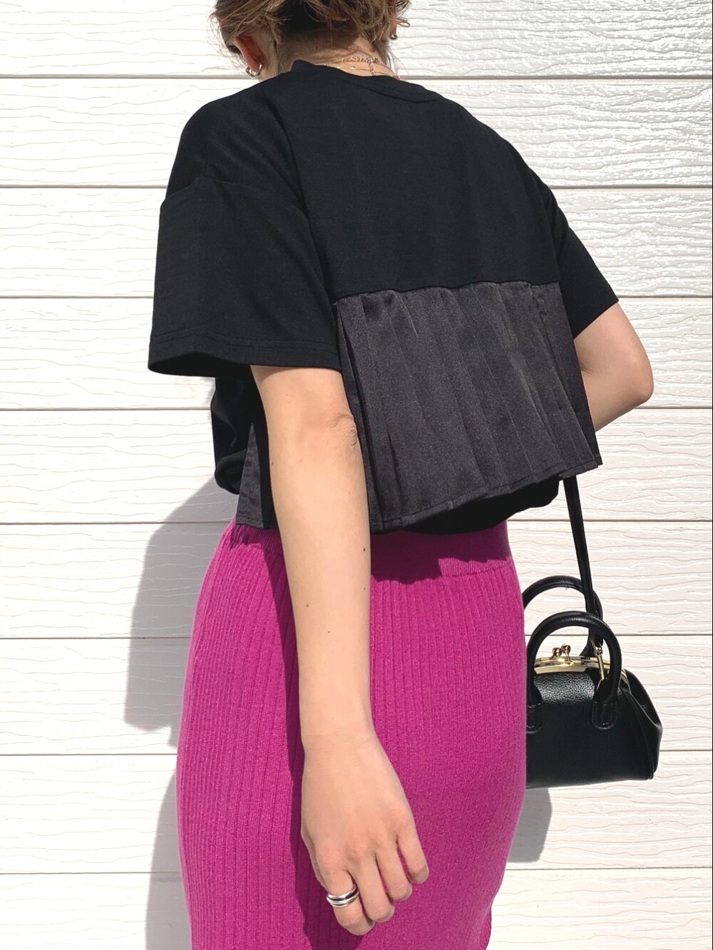 ブラック系のTシャツ/カットソー、ピンク系のスカート、ブラック系のサンダルを着用したレディースの春コーディネートの3枚目の写真