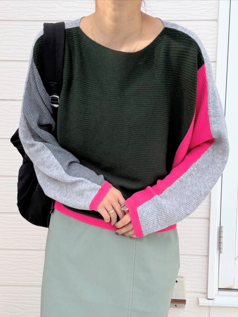 グリーン系のスカート、ブラック系のバックパック/リュック、グレー系のニット/セーターを着用したレディースの秋コーディネートの5枚目の写真