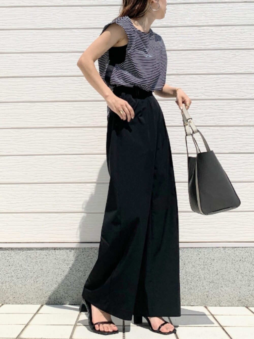 ブラック系のその他パンツ、グレー系のトートバッグ、ブラック系のTシャツ/カットソーを着用したレディースの春コーディネートの2枚目の写真