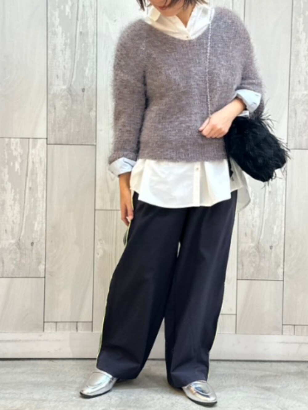 グレー系のその他パンツ、ホワイト系のシャツ/ブラウス、ブラック系のクラッチバッグを着用したレディースの冬コーディネートの2枚目の写真
