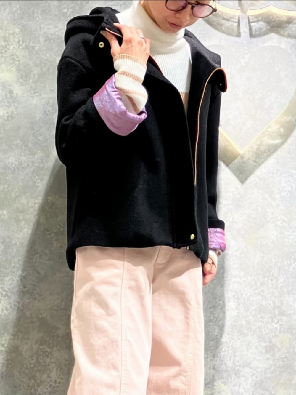 ブラック系のトートバッグ、ピンク系のデニムパンツ、ホワイト系のニット/セーターを着用したレディースの冬コーディネートの5枚目の写真