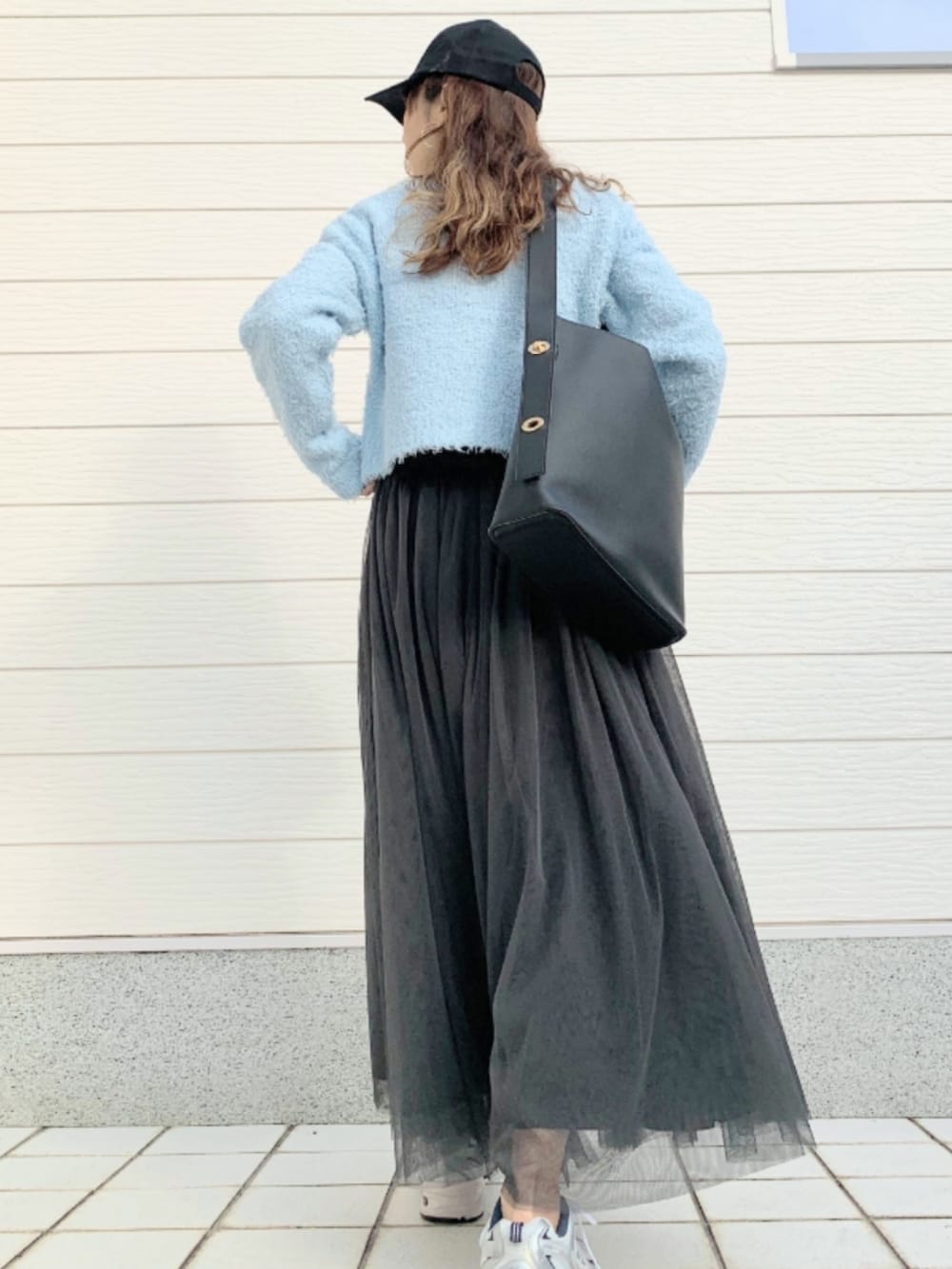 グレー系のスカート、シルバー系のスニーカー、ブルー系のカーディガン/ボレロを着用したレディースの冬コーディネートの2枚目の写真