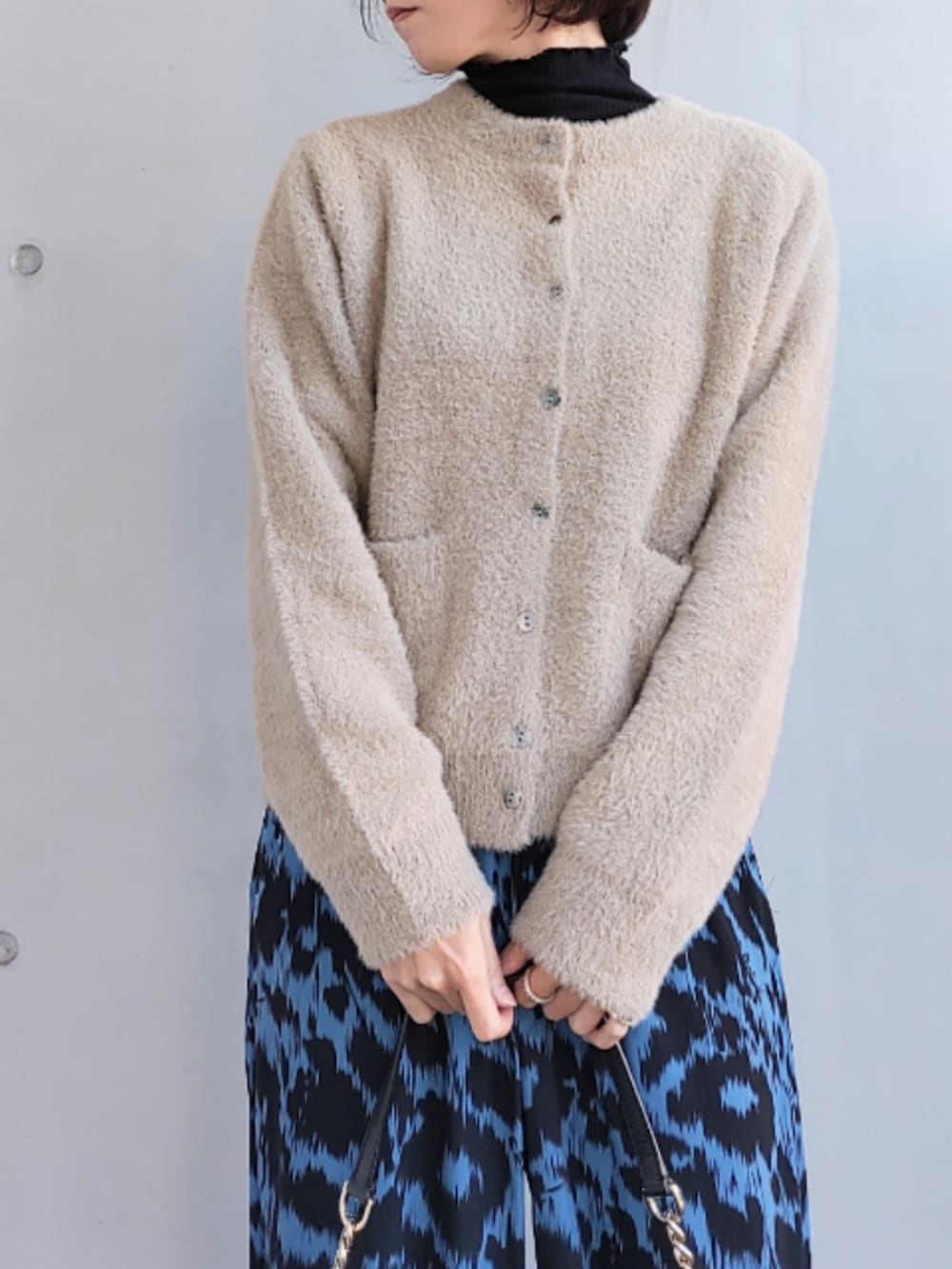 ブルー系のその他パンツ、ブラック系のバッグ、ベージュ系のカーディガン/ボレロを着用したレディースの秋コーディネートの3枚目の写真