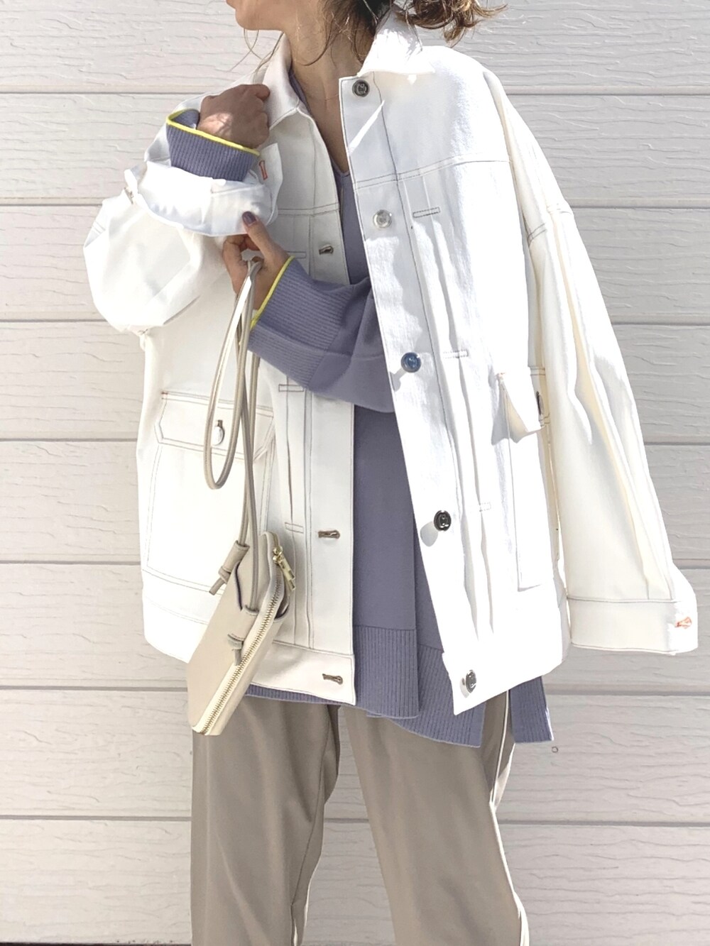 ホワイト系のデニムジャケット、パープル系のニット/セーター、ホワイト系のショルダーバッグを着用したレディースの冬コーディネートの4枚目の写真