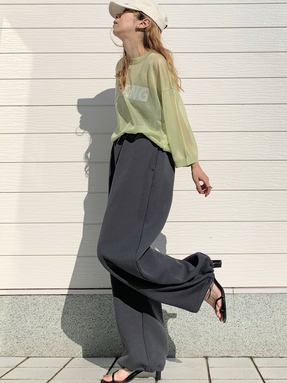 グリーン系のノーカラーコート、グリーン系のニット/セーター、ホワイト系のショルダーバッグを着用したレディースの春コーディネートの5枚目の写真