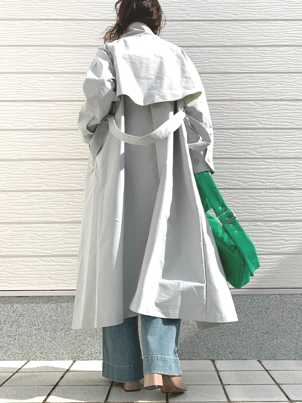 ブルー系のデニムパンツ、グリーン系のショルダーバッグ、ブラック系のニット/セーターを着用したレディースの冬コーディネートの4枚目の写真