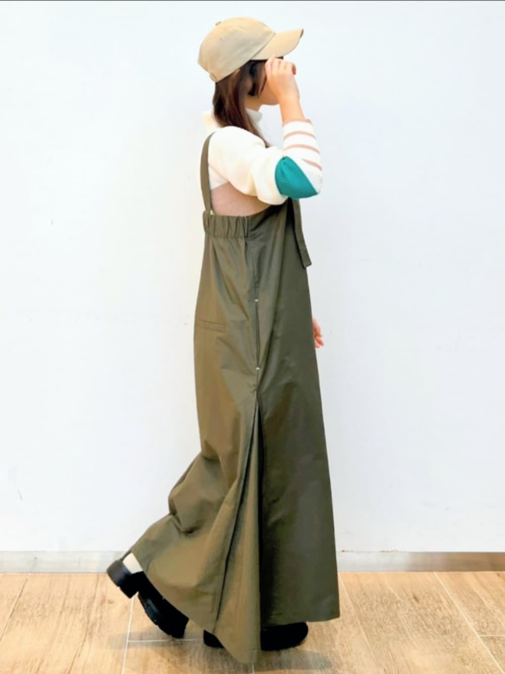 ホワイト系のブーツ、ホワイト系のニット/セーター、グリーン系のワンピースを着用したレディースの冬コーディネートの4枚目の写真