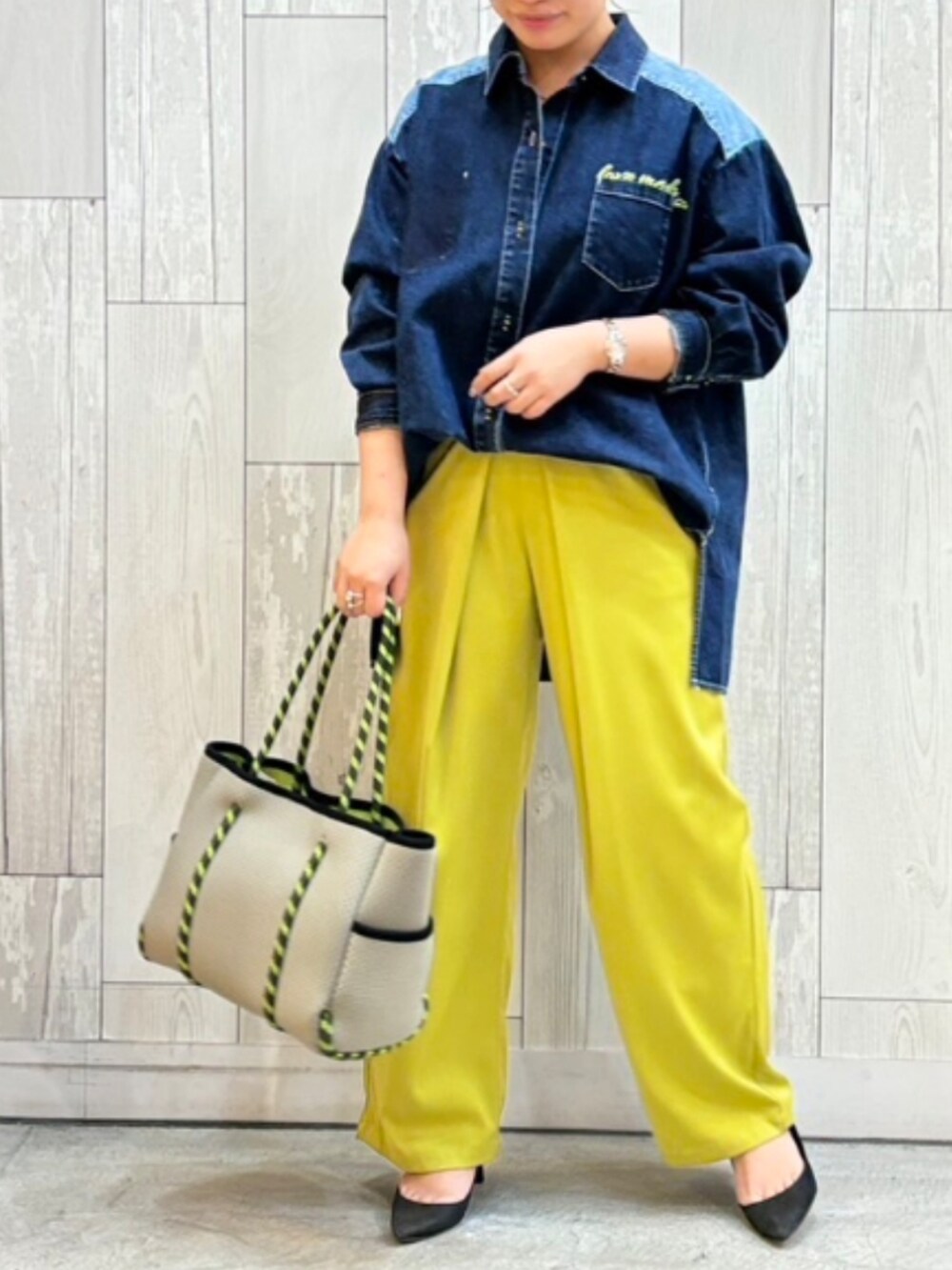 グレー系のトートバッグ、グリーン系のスラックス、ブルー系のシャツ/ブラウスを着用したレディースの冬コーディネートの2枚目の写真