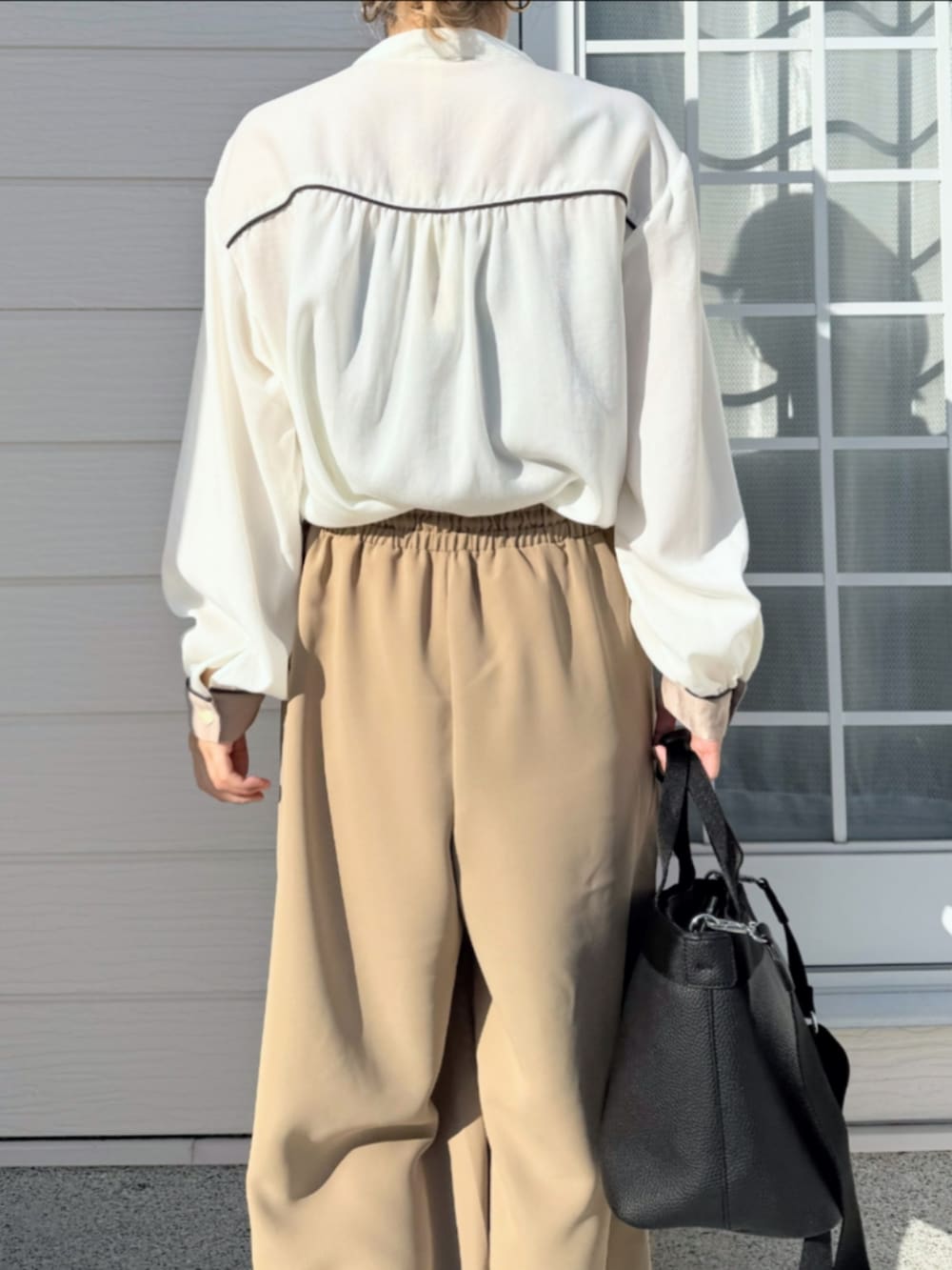 ブラック系のトートバッグ、ベージュ系のその他パンツ、ホワイト系のシャツ/ブラウスを着用したレディースの冬コーディネートの5枚目の写真