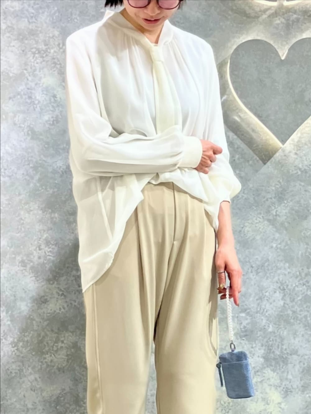 ベージュ系のその他パンツ、ホワイト系のシャツ/ブラウス、ブルー系のその他小物を着用したレディースの春コーディネートの4枚目の写真
